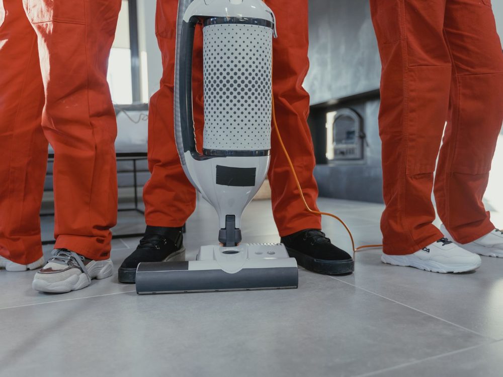 Équipe de nettoyage professionnelle avec aspirateur industriel